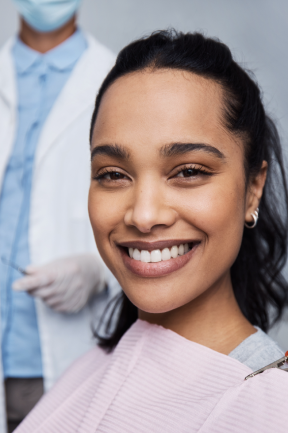 Patient sitting in a dental chair smiling after teeth whitening procedure